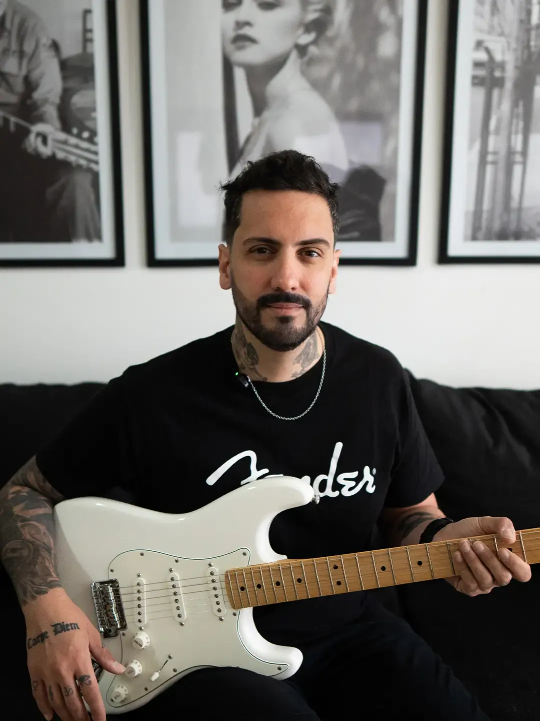 Guille, profesor de guitarra, sentado con una Stratocaster blanca y mirando a cámara